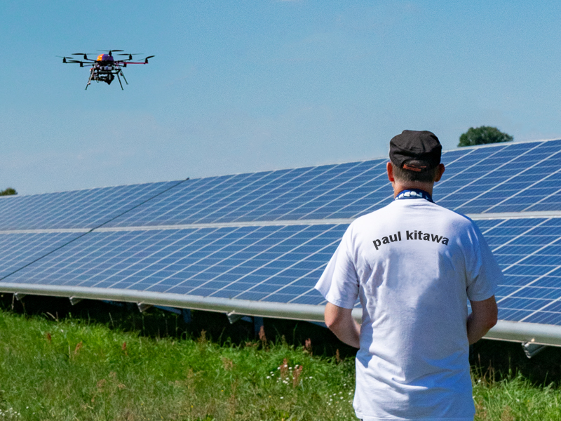 Pilot steuert Infrarot Drohne ueber Photovoltaikanlage