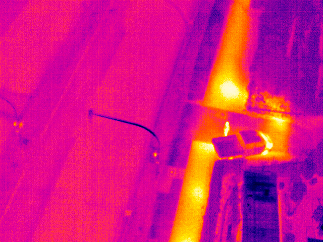 Thermografische Drohnenaufnahme einer unterirdischen Fernwärmeleitung mit auffälliger thermischer Anomalie im Bodenbereich