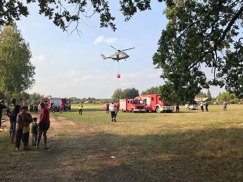 Hubschrauber mit Löschbehälter beim Waldbrand in der Königsbrücker Heide